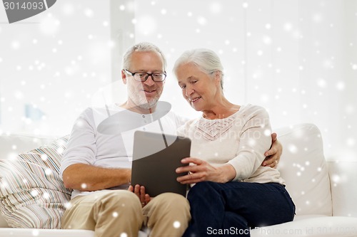 Image of happy senior couple with tablet pc at home