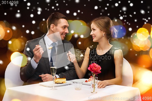 Image of smiling couple eating main course at restaurant