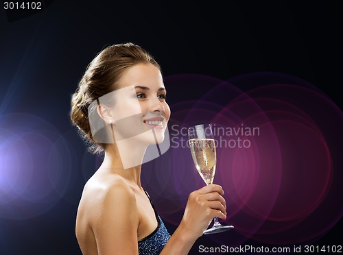 Image of smiling woman holding glass of sparkling wine