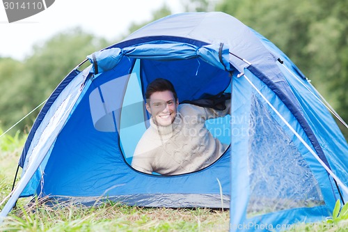 Image of smiling male tourist in tent