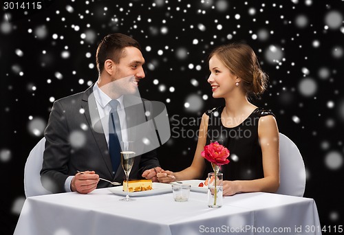 Image of smiling couple eating dessert at restaurant