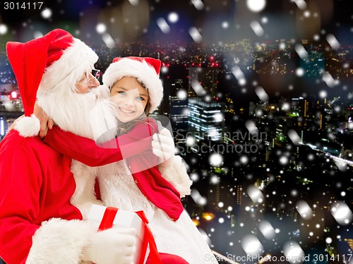 Image of smiling little girl with santa claus and gifts