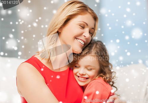 Image of happy mother and daughter hugging at home