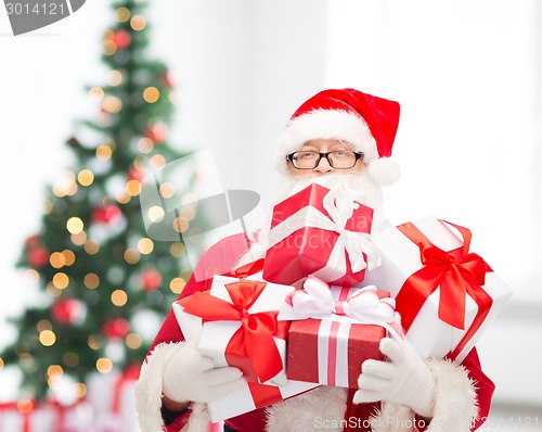 Image of man in costume of santa claus with gift boxes