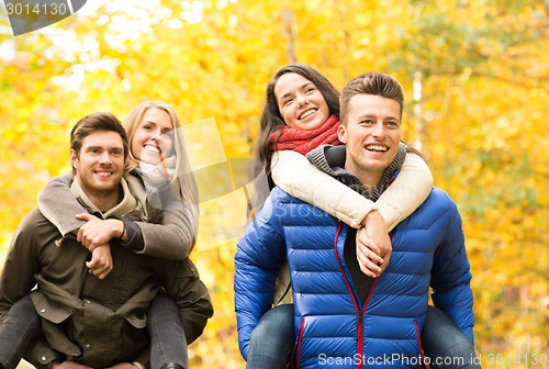 Image of smiling friends having fun in autumn park