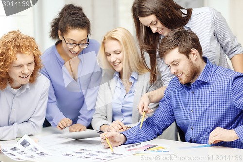 Image of smiling team with color samples at office