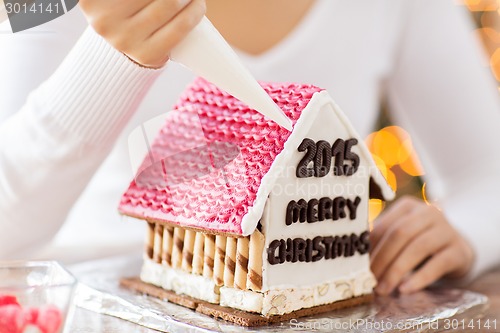 Image of close up of woman making gingerbread houses