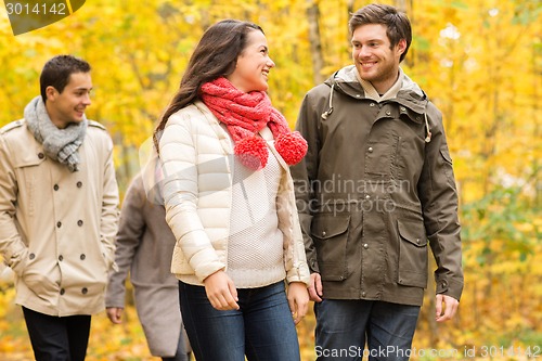 Image of group of smiling men and women in autumn park
