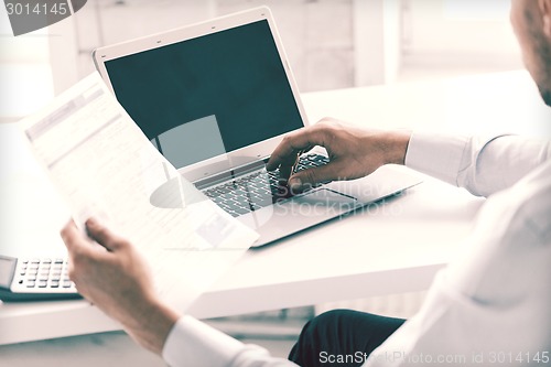 Image of miling businessman working in office