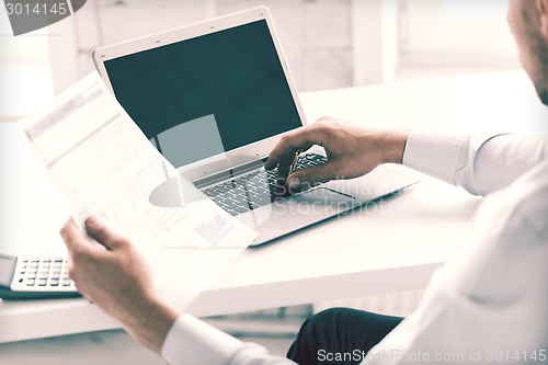 Image of miling businessman working in office