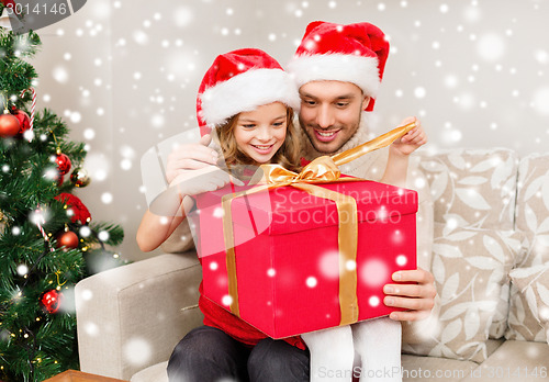 Image of smiling father and daughter holding gift box