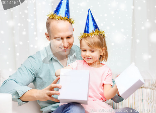 Image of father and daughter in party caps with gift box