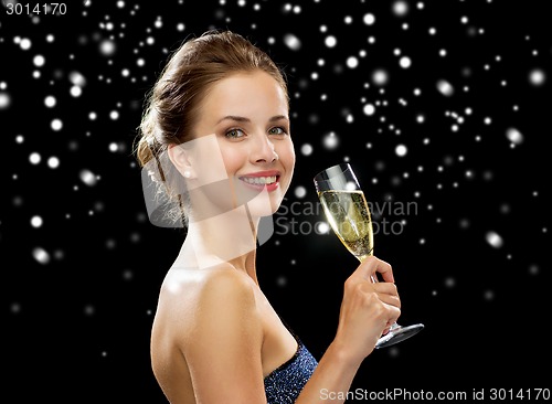 Image of smiling woman holding glass of sparkling wine