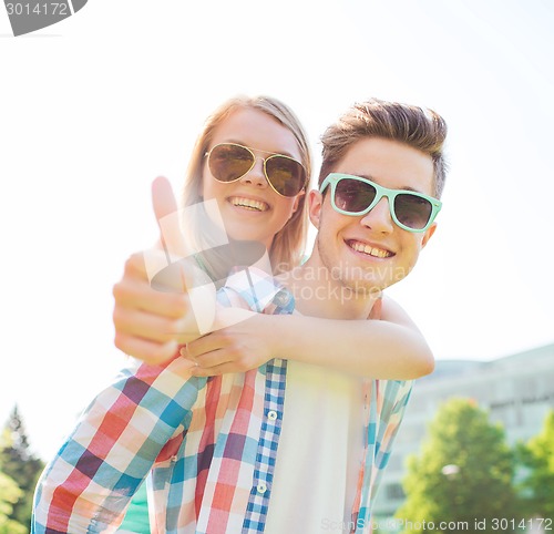 Image of smiling couple having fun and showing thumbs up