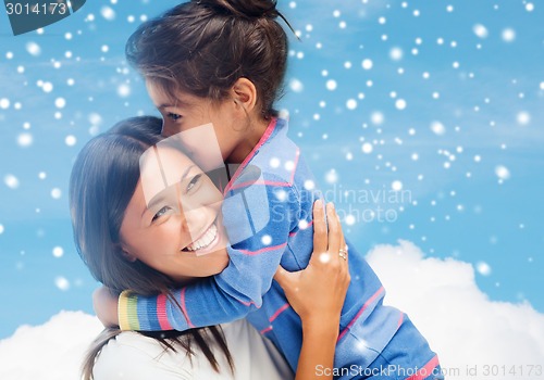 Image of smiling little girl and mother hugging indoors