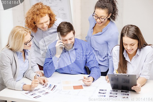 Image of creative team with papers and clipboard at office