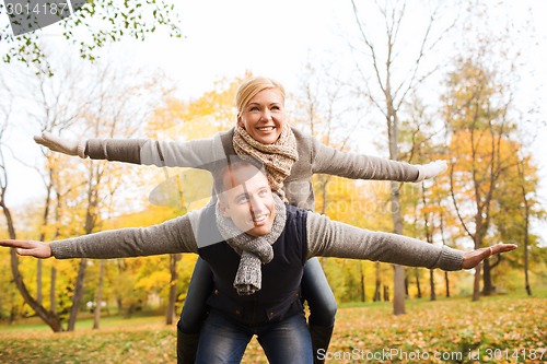 Image of smiling couple having fun in autumn park