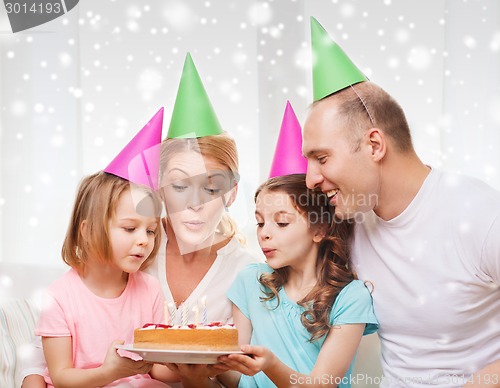 Image of happy family with two kids in party hats at home