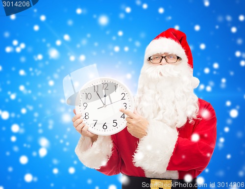 Image of man in costume of santa claus with clock