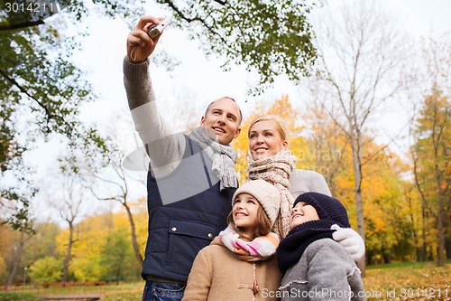 Image of happy family with camera in autumn  park
