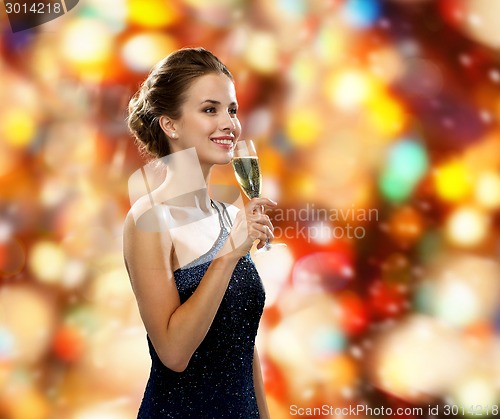 Image of smiling woman holding glass of sparkling wine