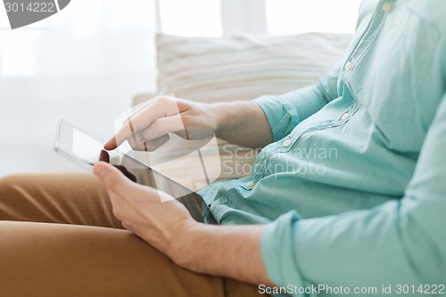 Image of close up of man with tablet pc computer at home
