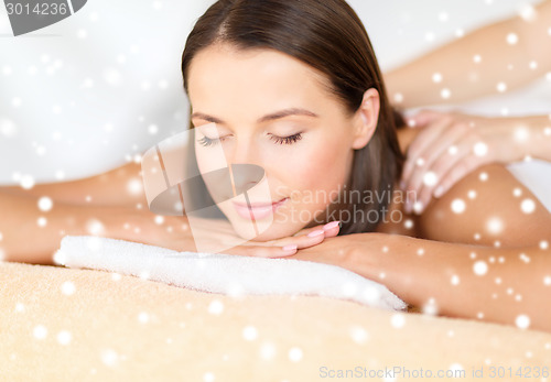 Image of beautiful young woman in spa salon getting massage