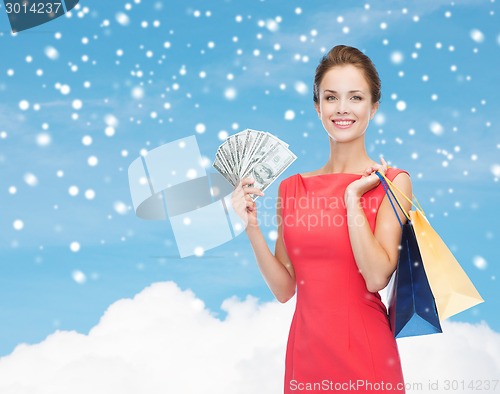 Image of smiling elegant woman in dress with shopping bags