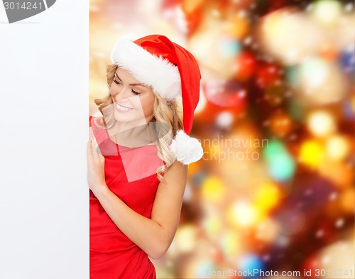 Image of smiling young woman in santa hat with white board