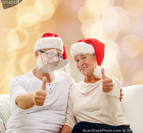 Image of happy senior couple in santa helper hats