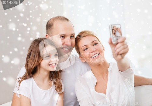 Image of happy family with camera taking picture at home