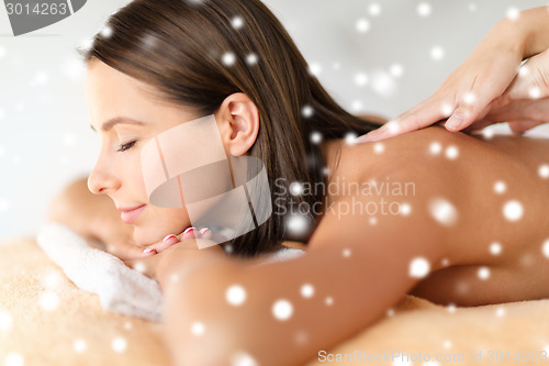 Image of beautiful young woman in spa salon getting massage