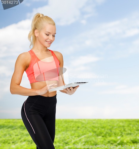Image of smiling sporty woman with tablet pc computer