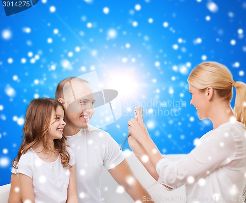 Image of happy family with camera at home