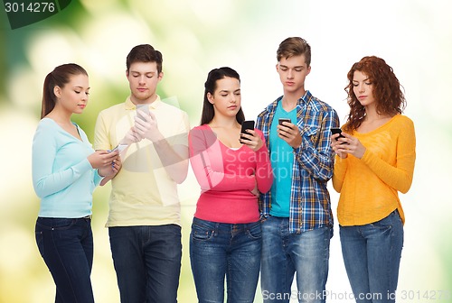 Image of group of smiling teenagers with smartphones