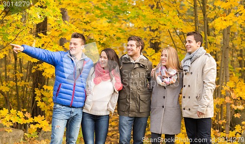 Image of group of smiling men and women in autumn park