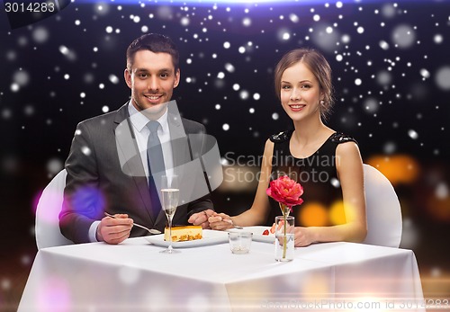 Image of smiling couple eating dessert at restaurant