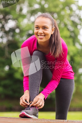 Image of smiling woman exercising outdoors