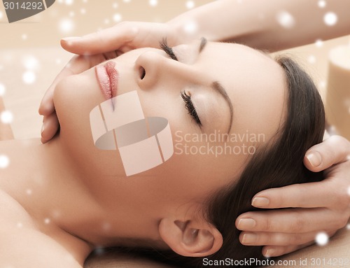 Image of beautiful woman getting face or head massage