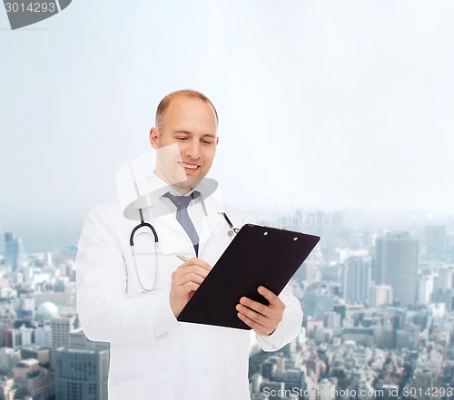 Image of smiling male doctor with clipboard and stethoscope