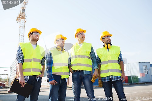 Image of group of smiling builders with tablet pc outdoors