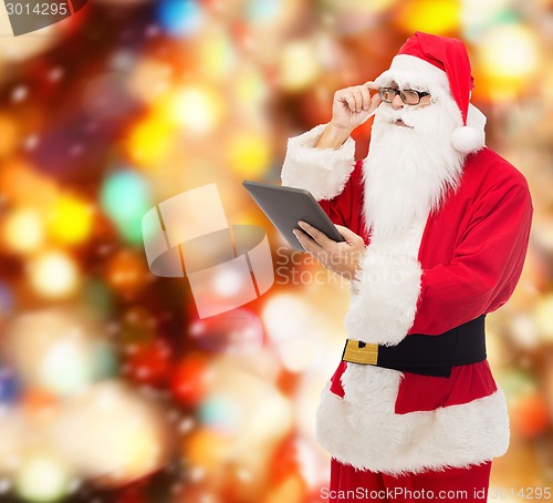 Image of man in costume of santa claus with tablet pc