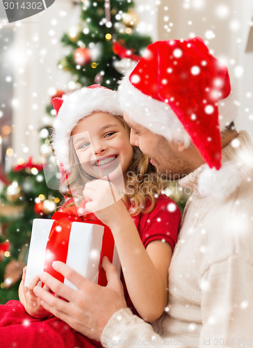 Image of smiling father and daughter holding gift box