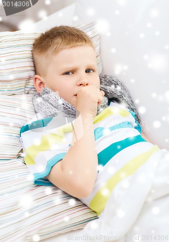 Image of ill boy with scarf lying in bed and coughing