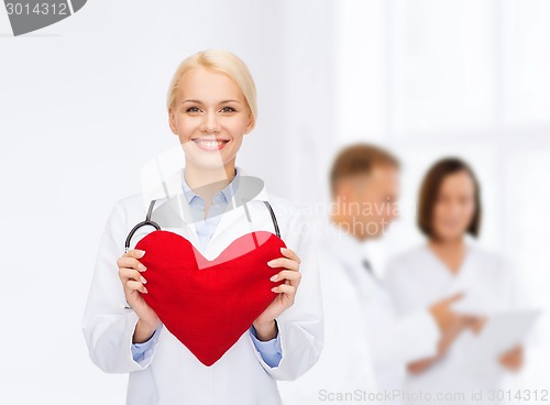 Image of smiling female doctor with heart and stethoscope