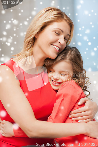 Image of happy mother and daughter hugging at home