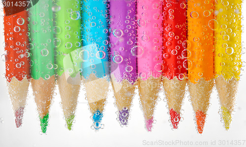 Image of Colorful pencils in water with bubbles, isolated on white