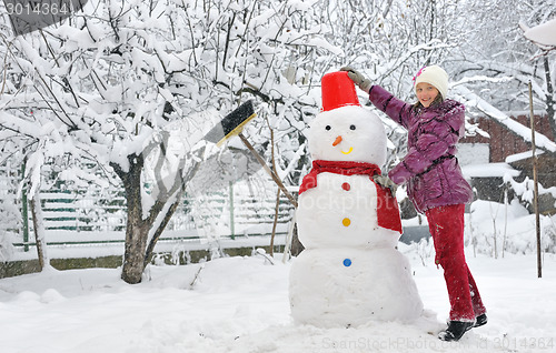 Image of snowman and young girl