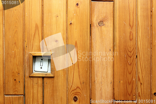 Image of old electric switch on wooden wall