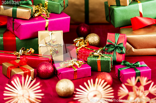 Image of Numerous Xmas Gifts Arranged on a Red Cloth